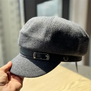 Grey wool newsboy cap detail, vintage baker boy hat with metal buckle strap texture.