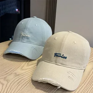 Close-up detail of the distressed baseball cap showcasing fine letter embroidery and soft brim.
