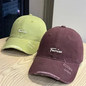 Distressed embroidered baseball cap detail showing soft top, wide brim, and cute letter embroidery.