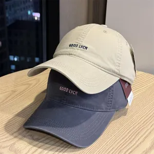 Detailed shot showing the texture and embroidery details of the washed cotton baseball caps.