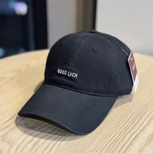 Detail view of the classic black washed cotton baseball cap featuring stylish white front embroidery.