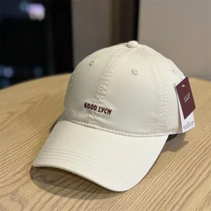 Detailed view of a retro washed cotton baseball cap in beige with embroidered text.