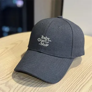Dark grey baseball hat detail, white embroidered letter design, casual unisex cotton cap.