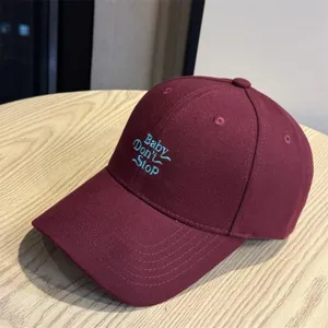 Maroon baseball cap with embroidered lettering detail, casual style accessory for daily wear.