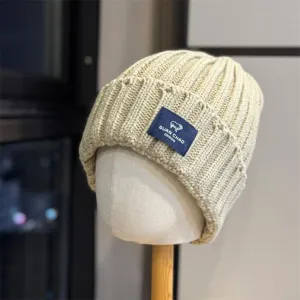 Close-up detail of the cozy knitted winter beanie with cute sheep logo patch and warm knit.