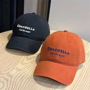 Detail view of stylish embroidered baseball caps in black and orange, perfect for casual outdoor wear.