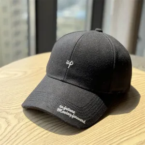 Gros plan de la casquette de baseball en laine gris foncé avec broderie élégante et visière.