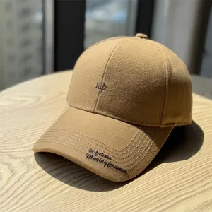Vue détaillée d'une casquette de baseball en laine camel élégante avec broderie délicate.