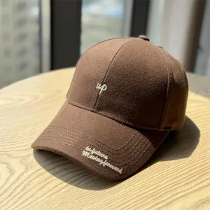 Vue détaillée de casquette de baseball en mélange de laine marron, brodée de lettres et visière.