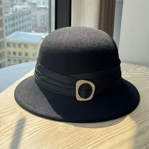 Classic black wool felt hat detail, featuring a pleated ribbon band and sparkling rhinestone buckle.
