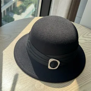 Detail view of the black wool fedora hat with elegant pleated band and sparkling rhinestone buckle.