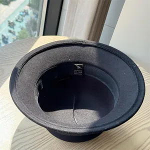 Black vintage felt bucket hat interior detail showing size 57 and polyester material.