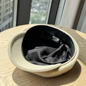 Classic wool newsboy hat detail view, showing soft fabric texture and inner label.