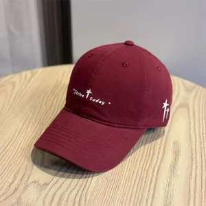 Primo piano dei dettagli del cappellino bordeaux con ricamo Strive today e stella bianca.