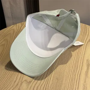 Dettaglio interno del berretto da baseball casual verde chiaro con cinturino regolabile e corona.