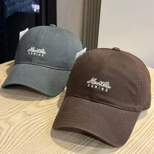 Detailed view of casual washed cotton baseball caps with trendy front embroidery text.