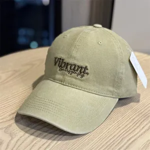 Detail view of khaki cotton baseball cap with front embroidery text and soft crown.