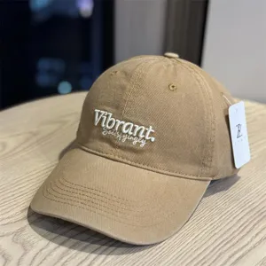 Detail view of the stylish khaki washed cotton baseball cap with front embroidery and wide brim.
