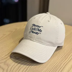 Detailansicht der beigen Baseballkappe mit dunkler Schreibschriften-Bestickung und breiter Krempe.