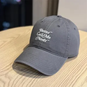 Nahaufnahme im Detail von dunkelgrauer Baumwoll-Baseballkappe mit weißer Schriftstickerei.