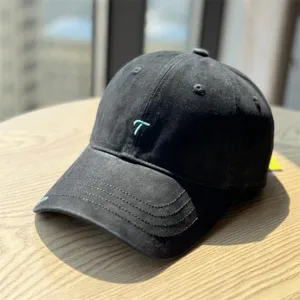 Detailed view of the black washed cotton baseball cap featuring stylish teal letter embroidery.