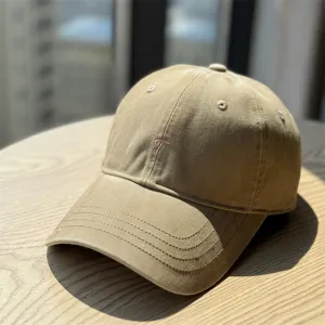 Detail view of a casual khaki baseball cap featuring delicate letter embroidery and curved brim.