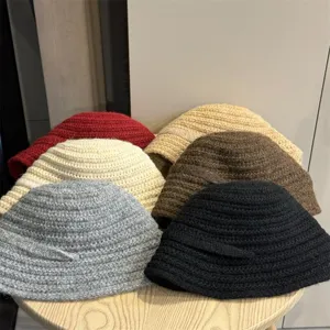 Detailansicht winterlicher Strick-Bucket-Hats in verschiedenen Farben, weiche Textur.