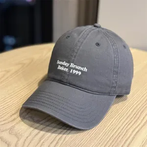 Detailed close-up shot of the dark grey baseball cap featuring white embroidered text.