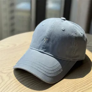 Close-up detail of the stylish blue baseball cap featuring neat embroidery and curved brim.