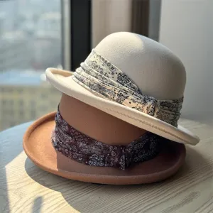 Detailed close-up of stacked wool felt bowler hats featuring stylish paisley ribbon bands.