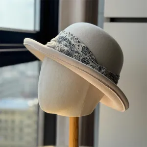 Chic beige wool fedora hat detail featuring stylish black and white paisley ribbon wrap.