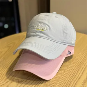 Detail view of soft crown baseball caps in light blue and pink with cute embroidery.