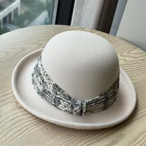 Detail view of women autumn winter wool felt cloche hat with stylish patterned scarf ribbon.