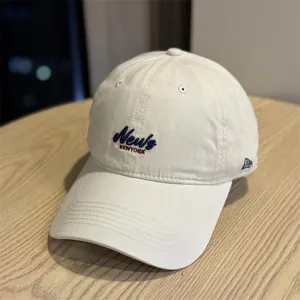 Detail view of the beige casual soft-top baseball cap with front embroidery and curved brim.