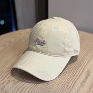 Beige soft-top baseball cap with embroidered lettering, casual outdoor sun protection hat.