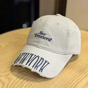 Detailed close-up of a vintage washed distressed baseball cap with blue embroidery.