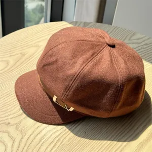 Brown wool newsboy cap detail, retro autumn winter hat with metal buckle accent, close up.