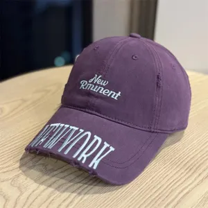 Vintage washed baseball cap with distressed brim and embroidered letters for men and women.