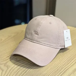 Washed cotton baseball cap with stylish cursive embroidery, casual unisex design for streetwear.