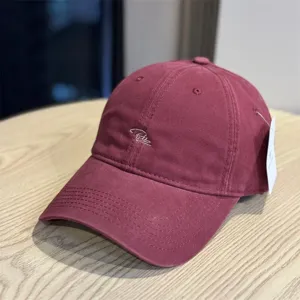 Detail view of a vintage washed cotton baseball cap featuring front cursive embroidery and tag.