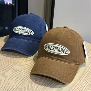 Detailed shot of vintage washed baseball caps in dark blue and brown with embroidered patch.