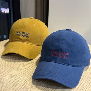 Detailed view of retro washed cotton baseball caps with custom letter embroidery in dual colors.