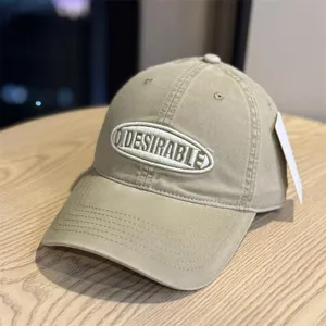 Washed cotton baseball cap detailed view, showing retro khaki color and embroidered logo.
