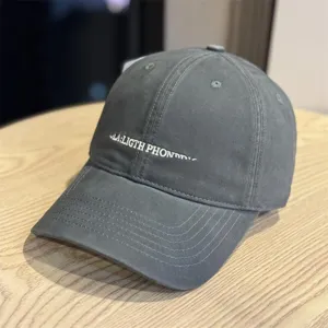 Detailansicht der stilvollen grauen Baseballcap mit weißer Front-Buchstabenstickerei.