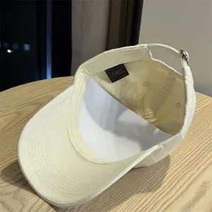 Detailed view of a vintage washed cotton baseball cap in beige, soft top casual hat.