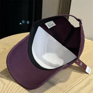 Detailansicht der dunkelvioletten Baumwoll-Baseballkappe, zeigt Etikett und weiche Kappe.