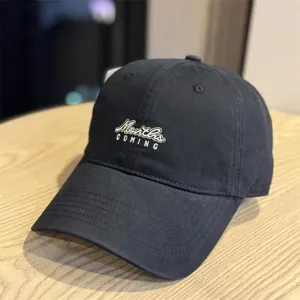 Details of the black washed cotton baseball cap with stylish embroidered lettering design.
