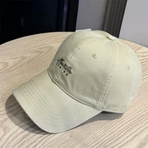 Washed cotton baseball cap with embroidered lettering, soft top design, casual sun protection hat.