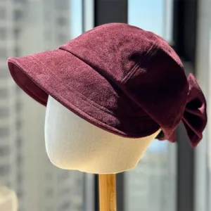 Close-up detail of the burgundy velvet newsboy hat with a cute back bow, retro style.