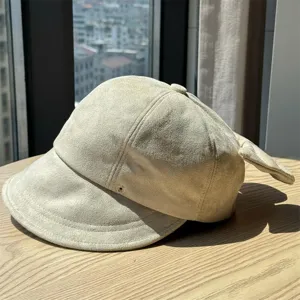 Close-up detail of beige suede newsboy hat, vintage cabbie cap style, autumn fashion headwear.